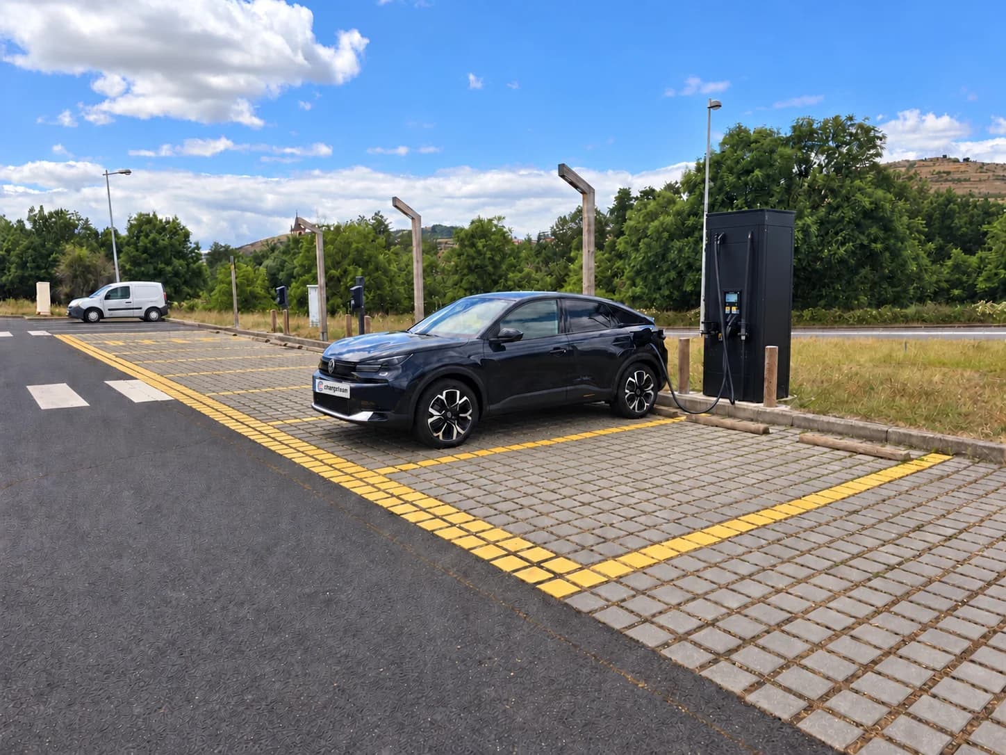 ChargeTeam-Auto an einer Schnellladesäule auf einem Parkplatz