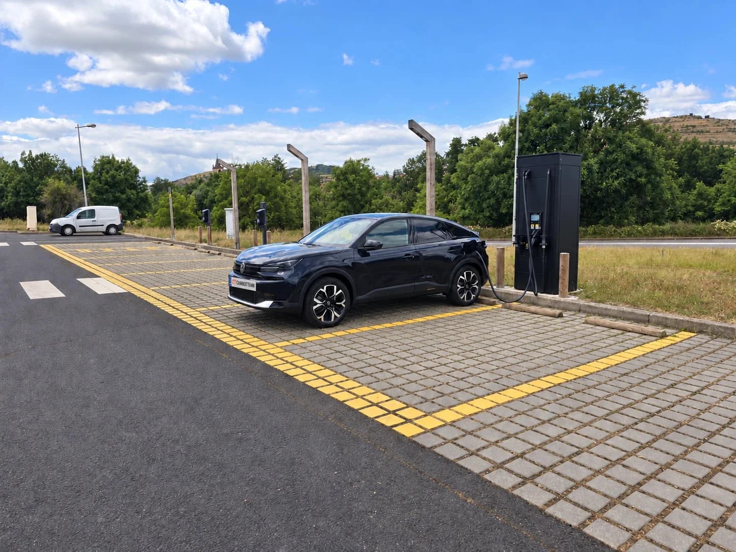 Voiture ChargeTeam branchée à une borne de recharge rapide sur un parking