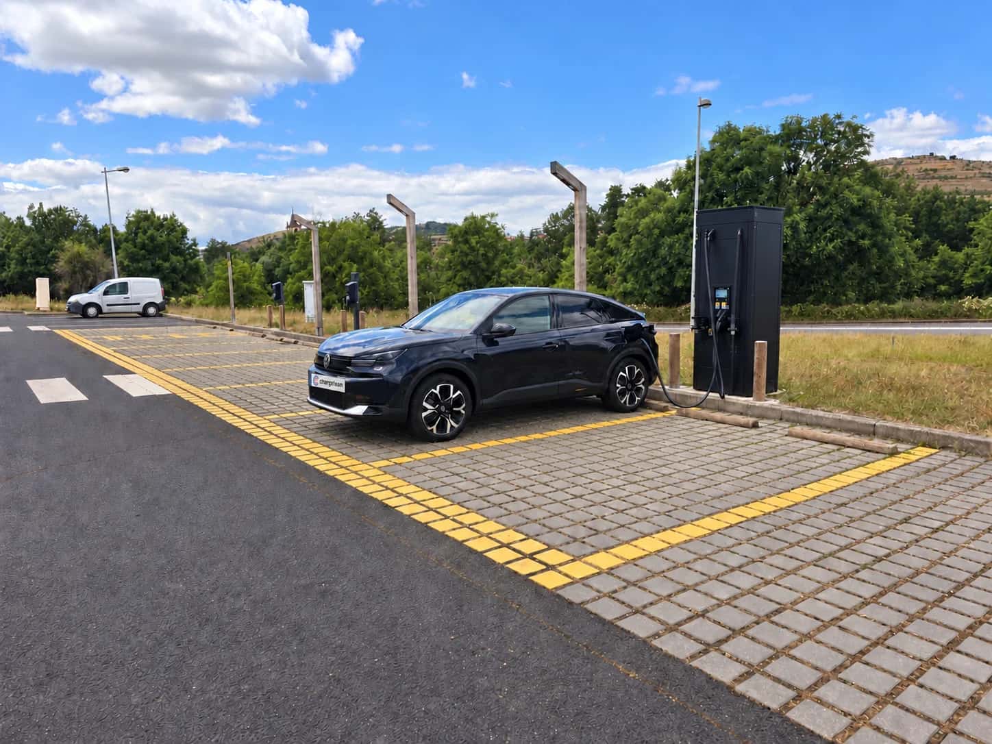 Coche de ChargeTeam conectado a un cargador rápido en un aparcamiento